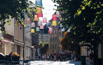 Scène de rue colorée avec des lanternes suspendues à Amiens, mettant en valeur l'architecture européenne.