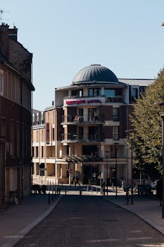 Charming street view featuring Mercure Hotel in Amiens, showcasing classic European architecture on a sunny day.