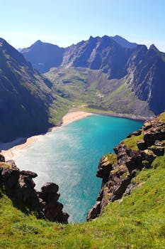 A stunning aerial view of Kvalvika Beach nestled amidst Lofoten's rugged mountains.