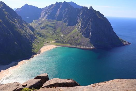 A breathtaking aerial view of Kvalvika Beach on Lofoten Islands with mountains and turquoise sea.