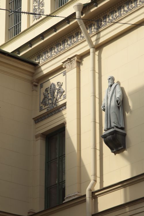 Free Elegant architecture featuring a statue on a historic building's facade in daylight. Stock Photo