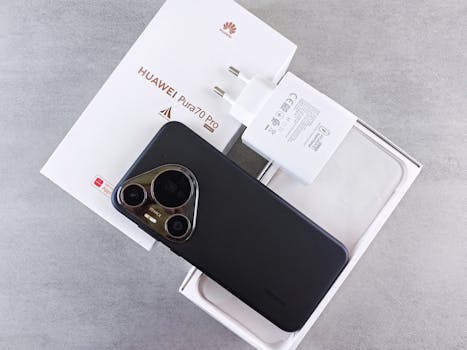 Flat lay of HUAWEI P70 Pro box, phone, and charger on gray surface.