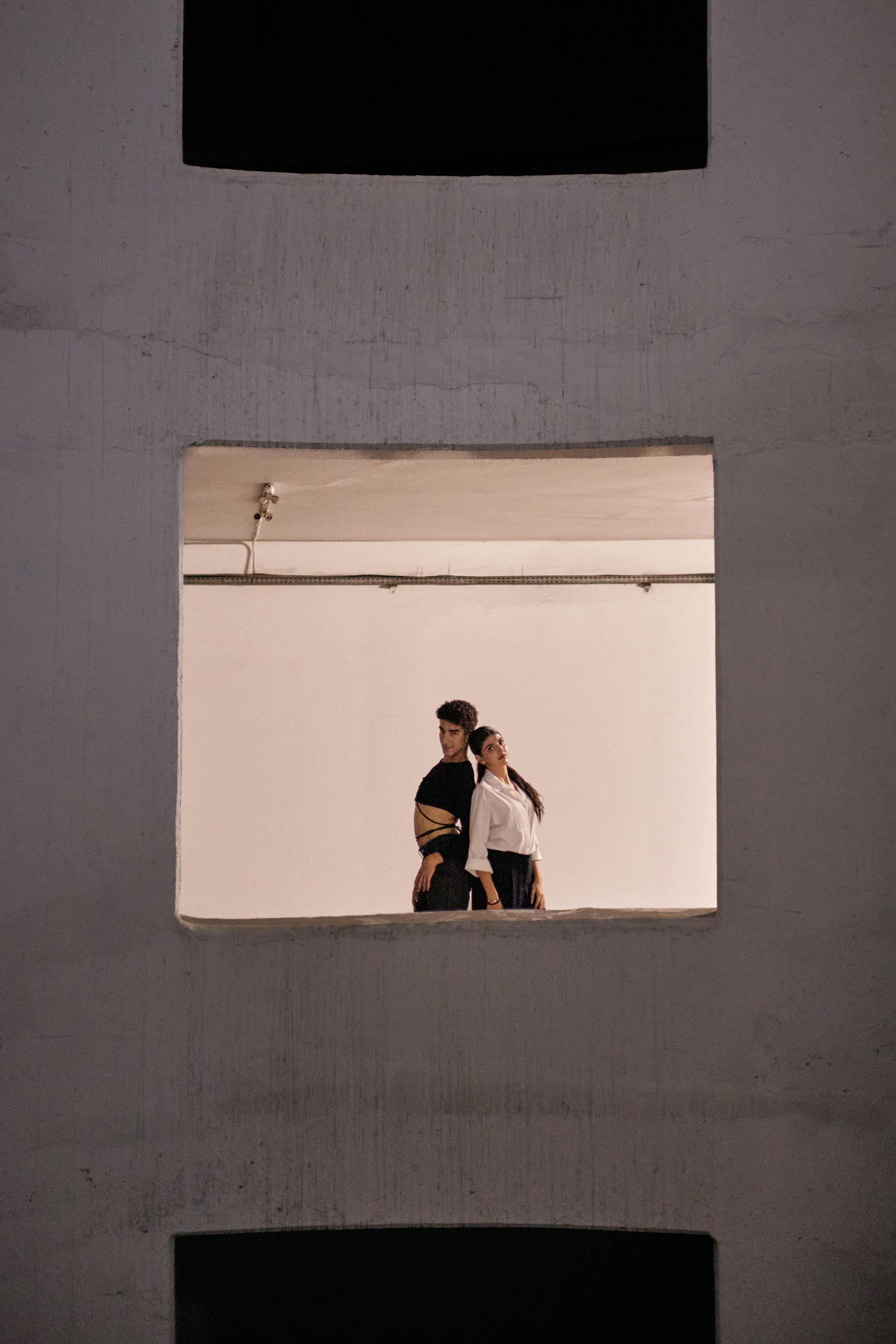 De franc Parella moderna posant elegantment a l'estudi d'Istanbul, capturada a través del marc d'una finestra. Ambient modern i artístic. Foto d'estoc