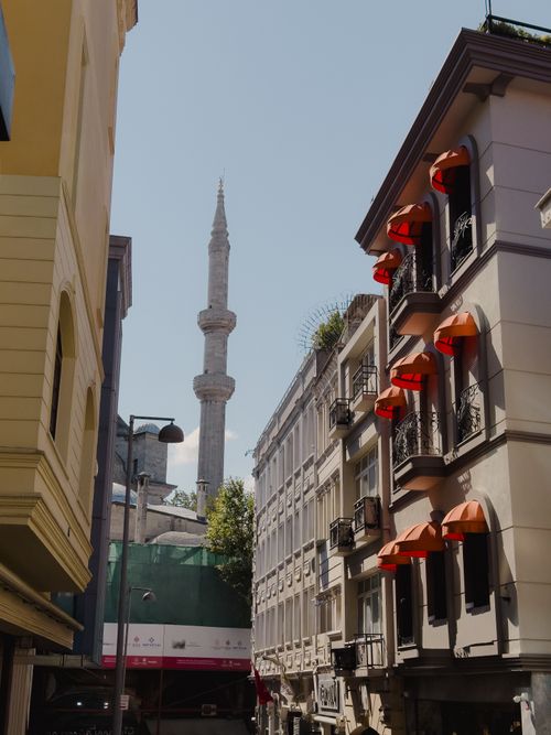 Free Captivating urban street view with a mosque's minaret against a clear sky. Stock Photo