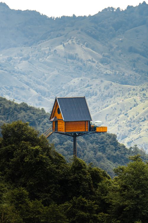 Free Scenic view of a wooden treehouse on stilts in Norway's lush mountains. Stock Photo