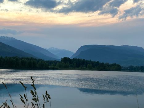 Serene landscape of mountains and river under a hazy sky in Revelstoke, BC, Canada.