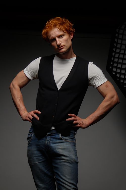 Free Portrait of a redheaded man in casual attire posing confidently in a studio setting. Stock Photo