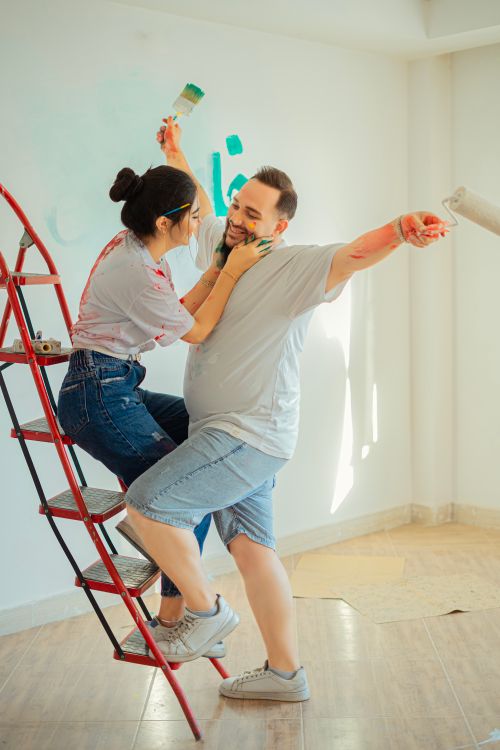 Free Happy couple playfully painting a room in Qazvin, capturing a joyful DIY home project moment. Stock Photo