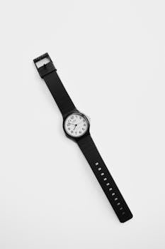 A simple black and white analog wristwatch on a white background, showcasing minimalist design.