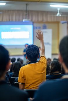 A student raises his hand during a seminar in an educational setting. - Fotografer Sidoarjo
