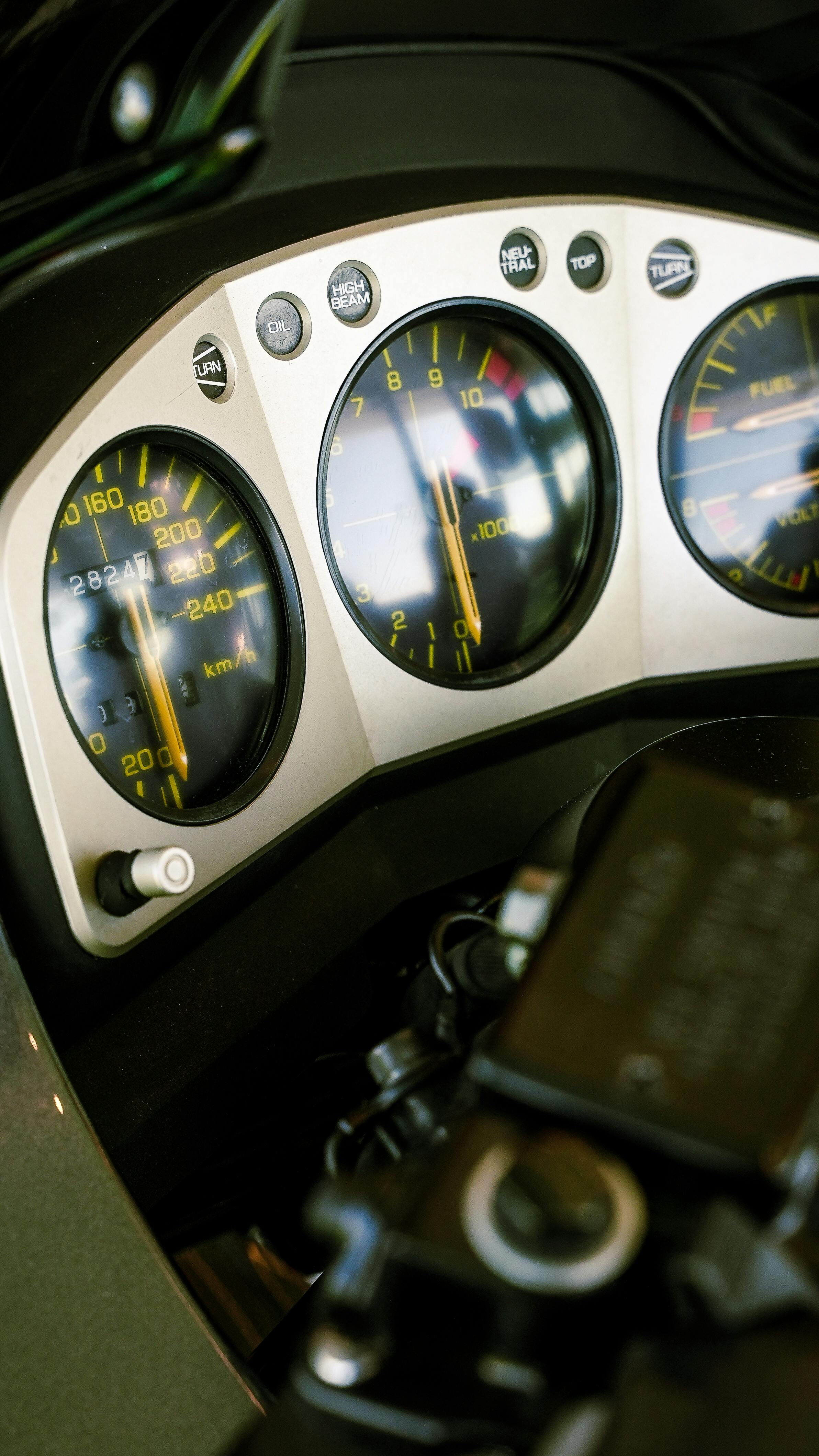 Detailed view of a motorcycle speedometer and dashboard showcasing speed and fuel gauges.