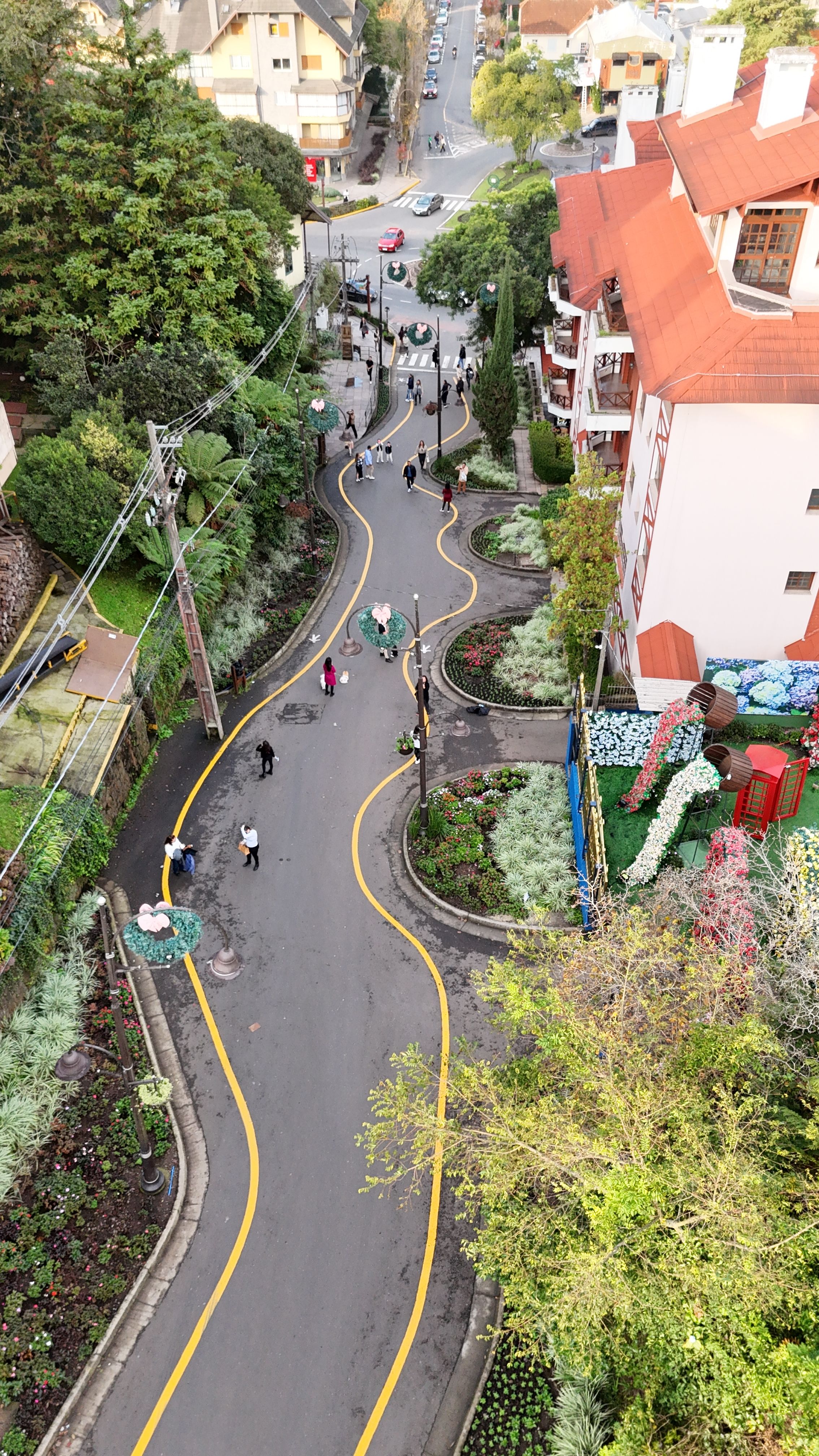 Rua sinuosa em Gramado com curvas, flores e paisagismo