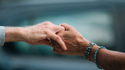 A heartfelt image of two elderly individuals holding hands, symbolizing love and support.
