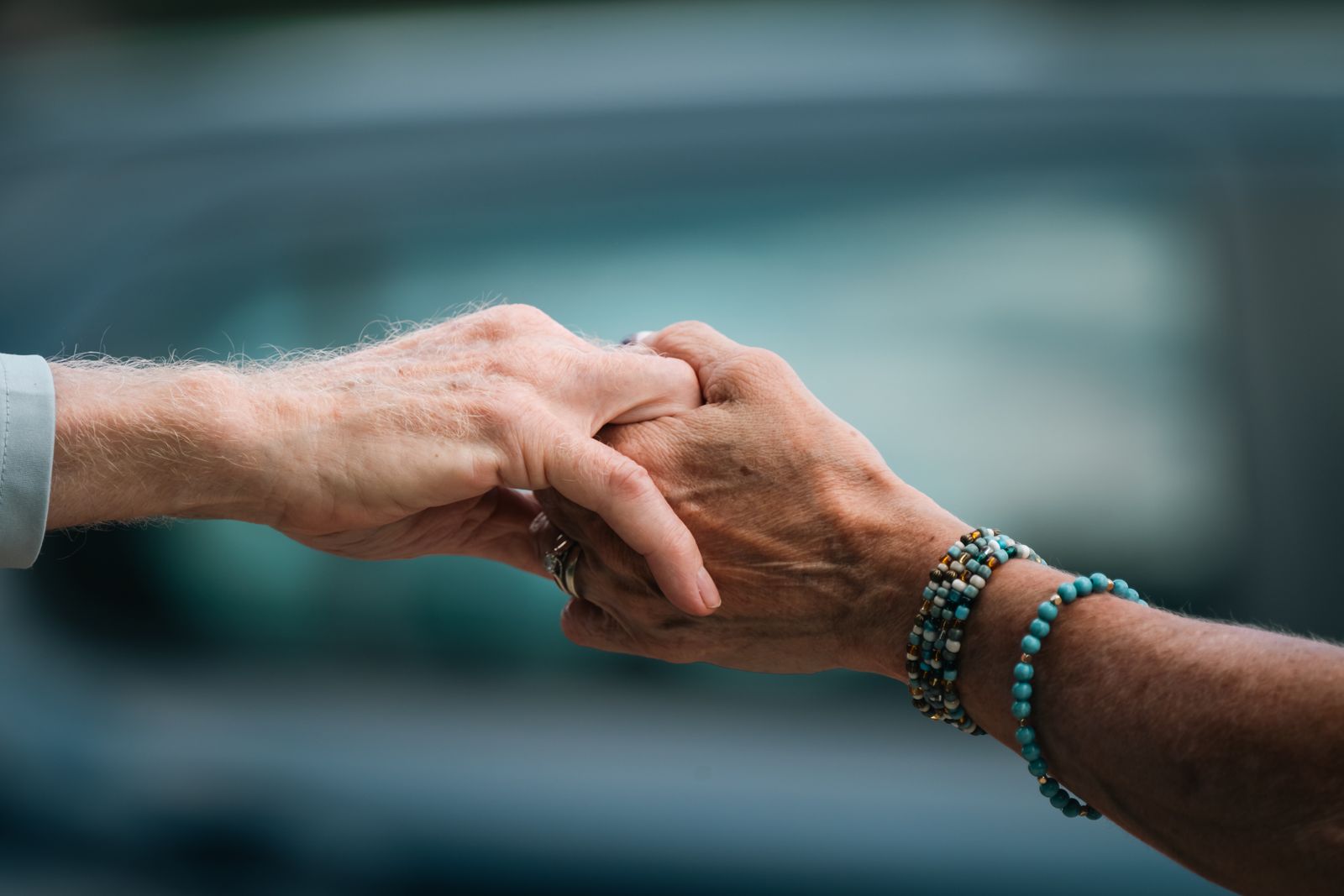 Bright close-up of a person holding their wrist and thumb during an outdoor activity