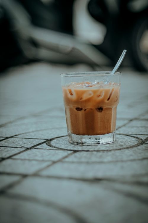 Free Glass of iced coffee on pavement, highlighting texture and mood. Stock Photo