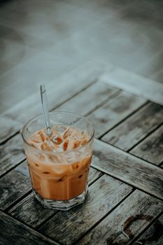 Chilled iced coffee served in a glass on a vintage wooden table.