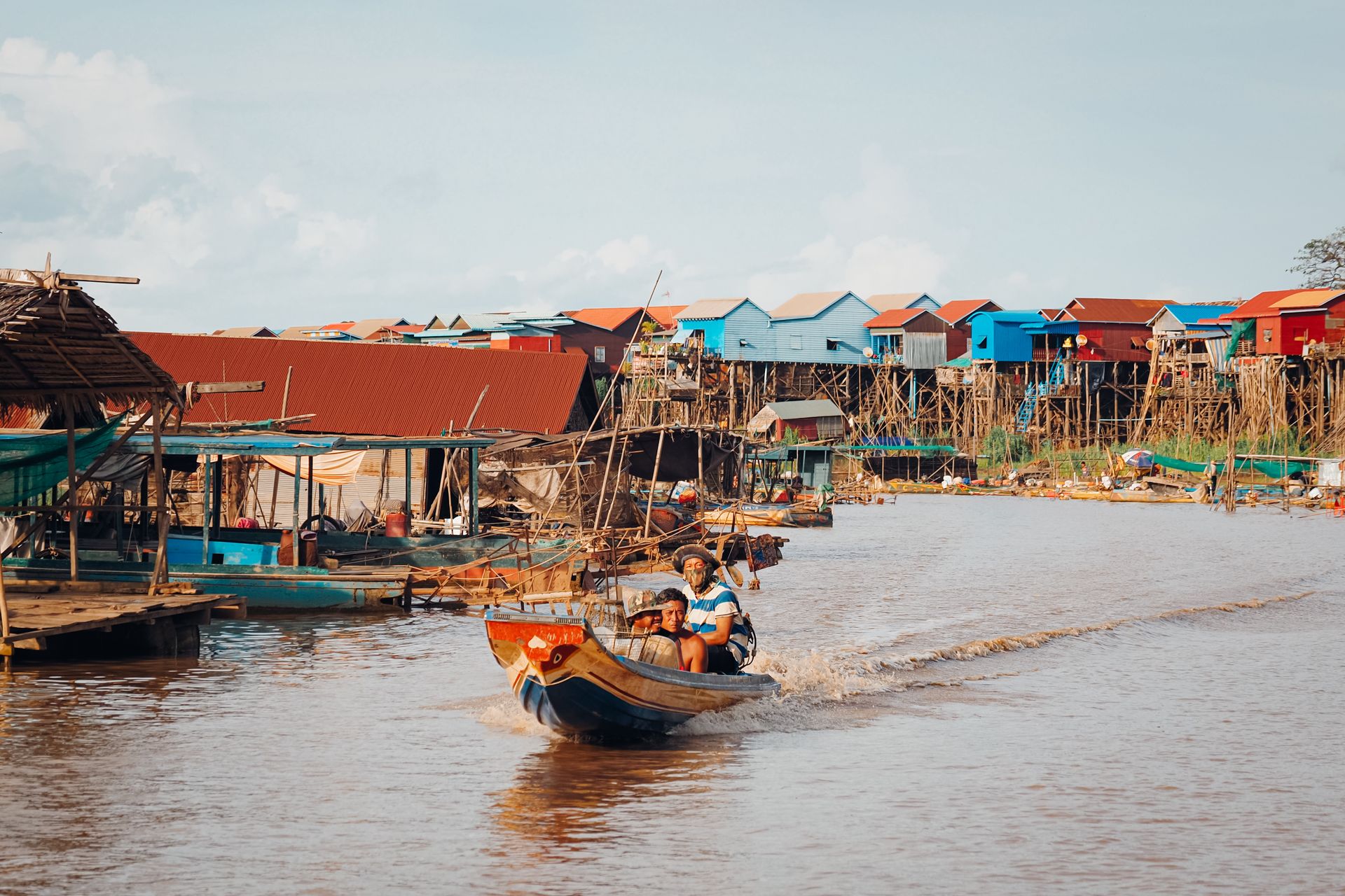 Vibrant boats and stilt houses in Kampong Khleang, capturing traditional Cambodian riverside living.