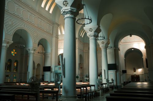 Free Interior view of a historic church with arches and columns, capturing serene architecture. Stock Photo