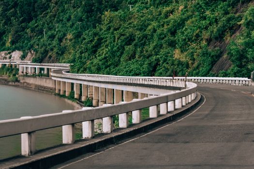 Curving coastal highway along lush greenery in the Ilocos Region, offering a picturesque view of nature and engineering.