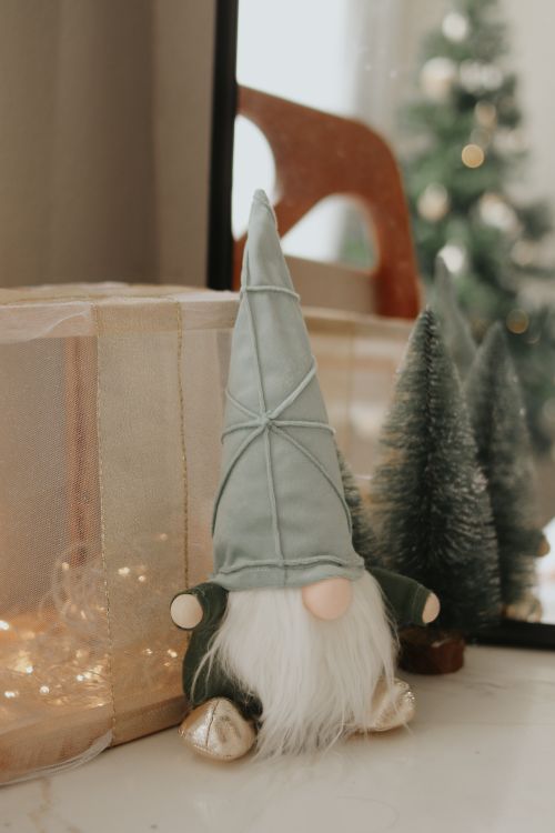 Free Charming gnome figurine with holiday decorations. Ideal for festive home decor. Stock Photo