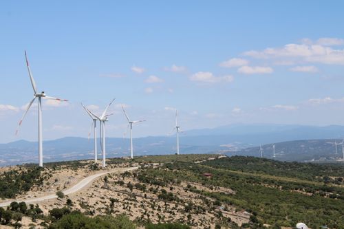 Free Scenic view of wind turbines on rolling hills in Behram, Çanakkale, Türkiye under a clear blue sky. Stock Photo