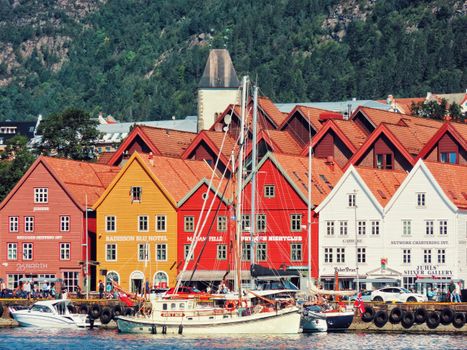 Charming scene of Bryggen waterfront in Bergen, Norway with vibrant buildings and boats.