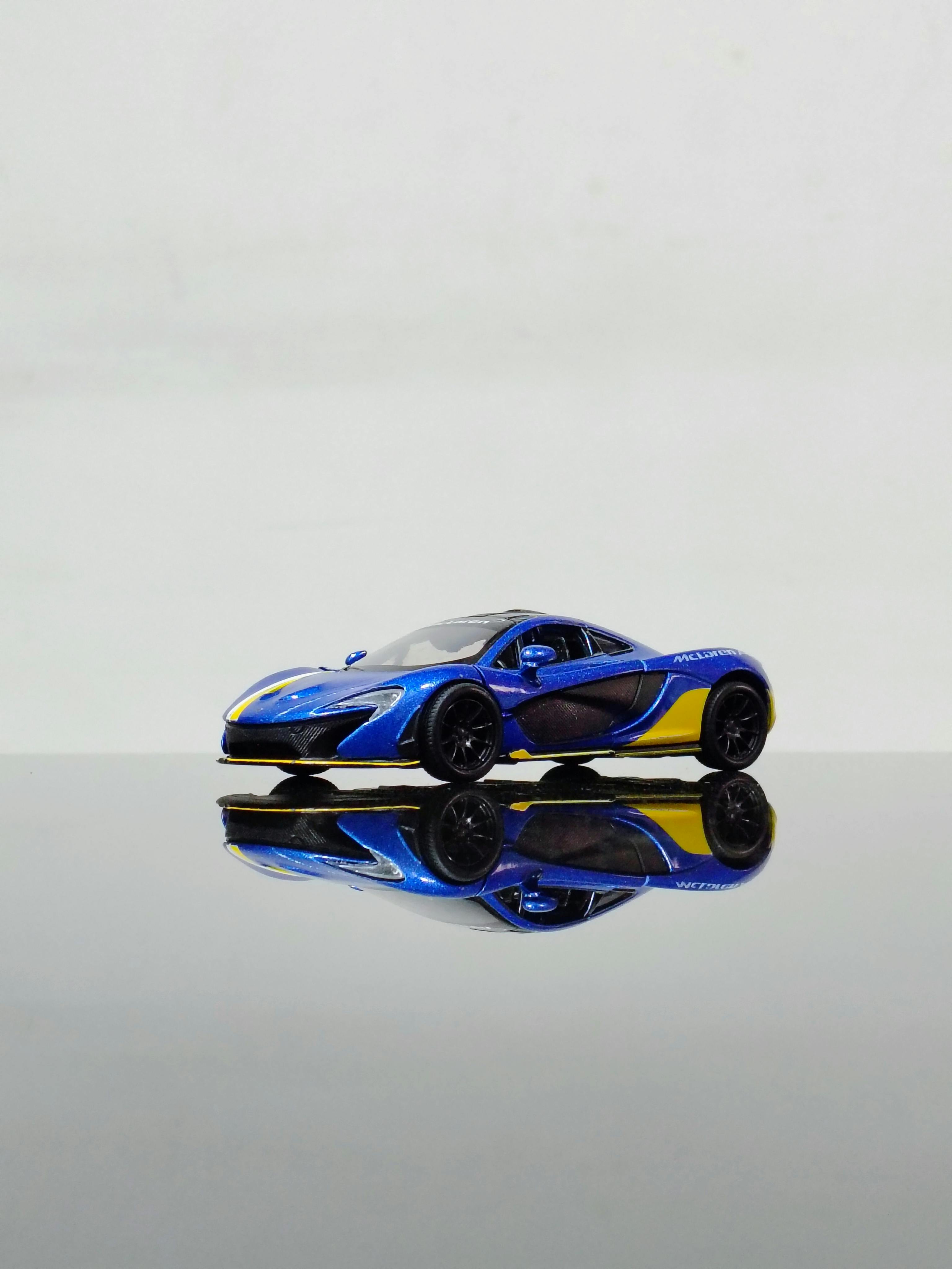 bezplatná Detailní záběr na modrožlutý miniaturní model superauta odrážející se na hladkém povrchu. Základová fotografie