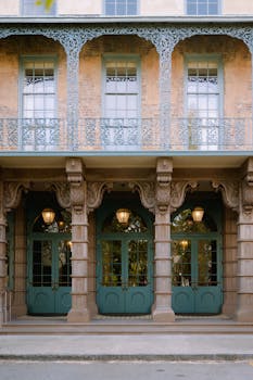Elegant colonial building facade in Charleston, showcasing intricate ironwork and pastel hues, reflecting historical charm.