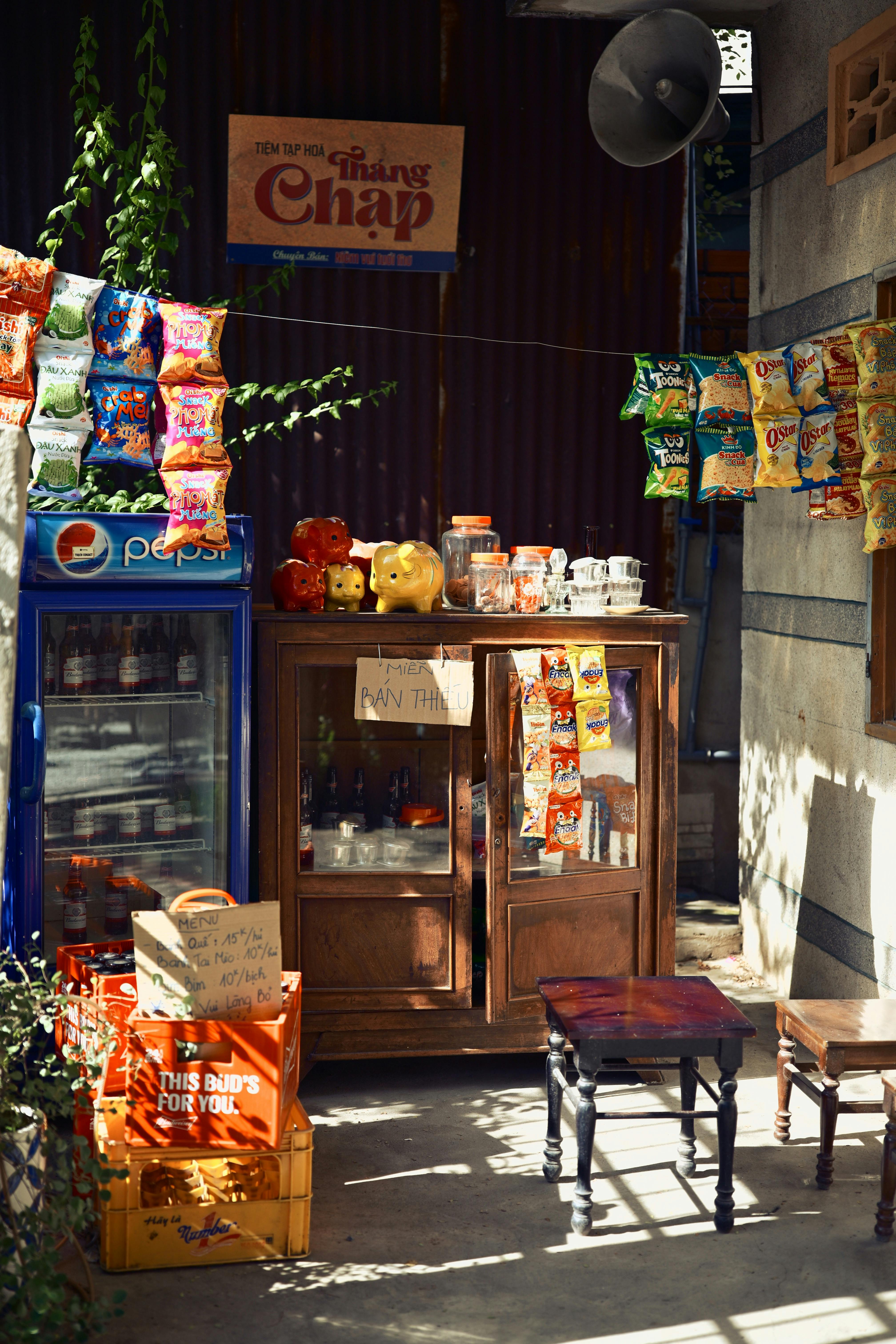 Vibrant street food stall in Vietnam with snacks and drinks under sunlight.