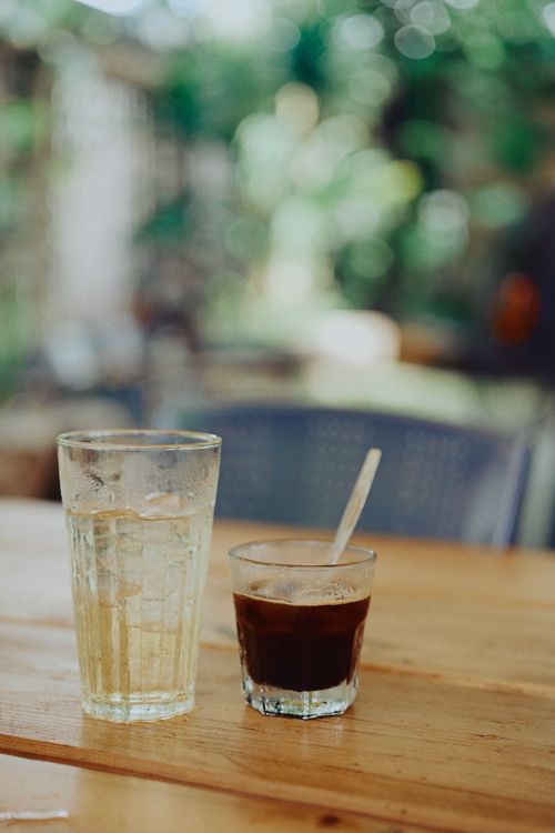 Free Refreshing iced tea and strong black coffee served on a sunny wooden table outdoors. Stock Photo