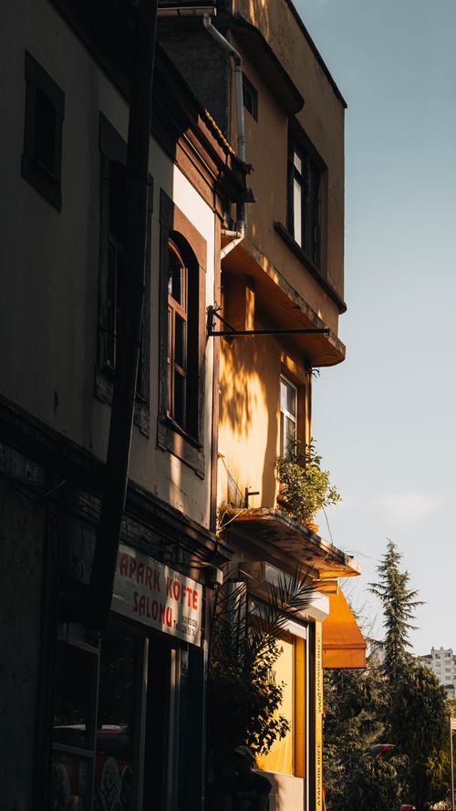 Free A peaceful urban street with sunlit building facades exuding a warm, inviting ambience. Stock Photo