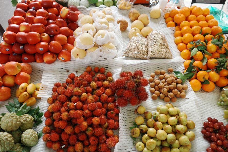 A colorful display of tropical fruits at a market stall in Ho Chi Minh City, Vietnam.