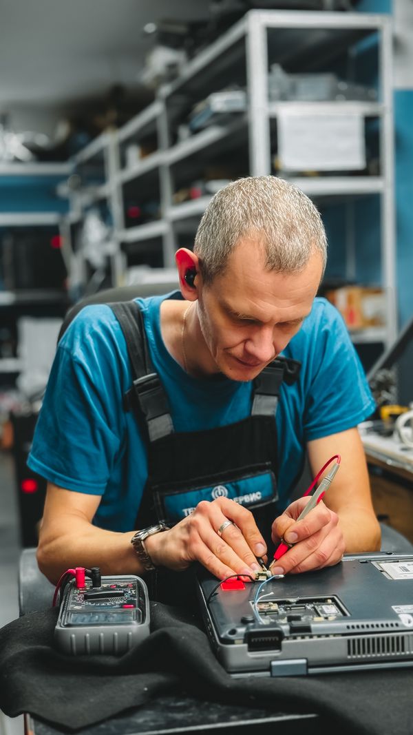 Technician repairing laptop in workshop