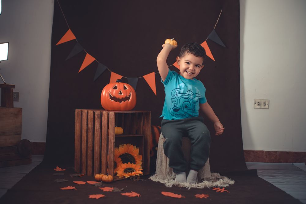 Niño disfrutando de una celebración de Halloween con decoración de calabazas