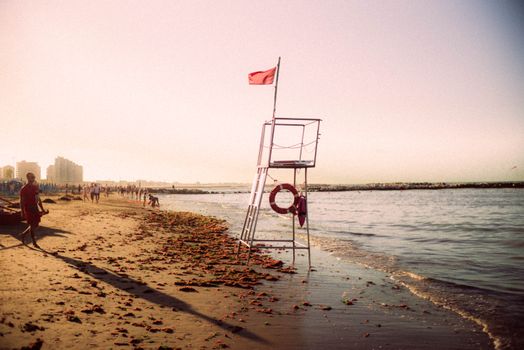 宁静的清晨，海滩上矗立着救生员站，沐浴在柔和的曙光中