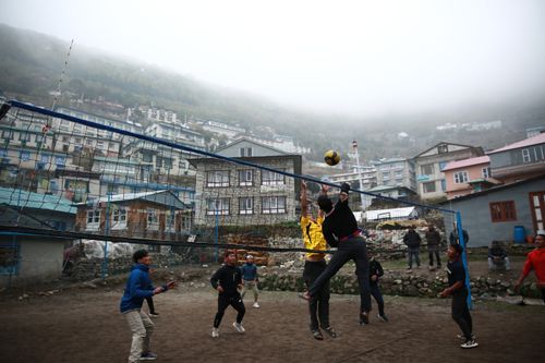 Free A group of men playing volleyball in the scenic setting of Namche, Koshi Province, Nepal. Stock Photo