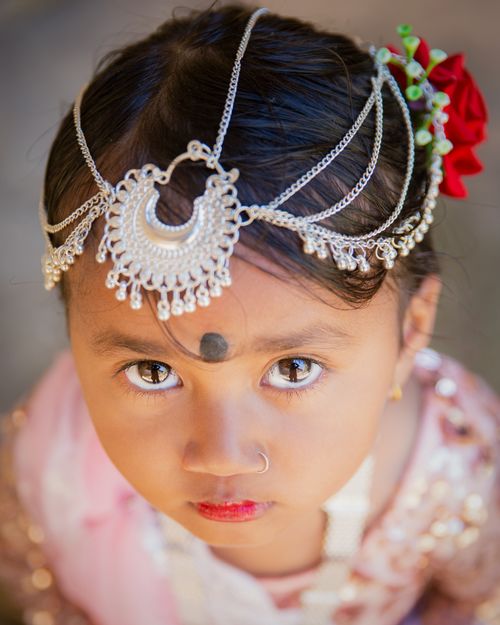 Free Close-up of a child wearing traditional jewelry, gazing intently. Stock Photo