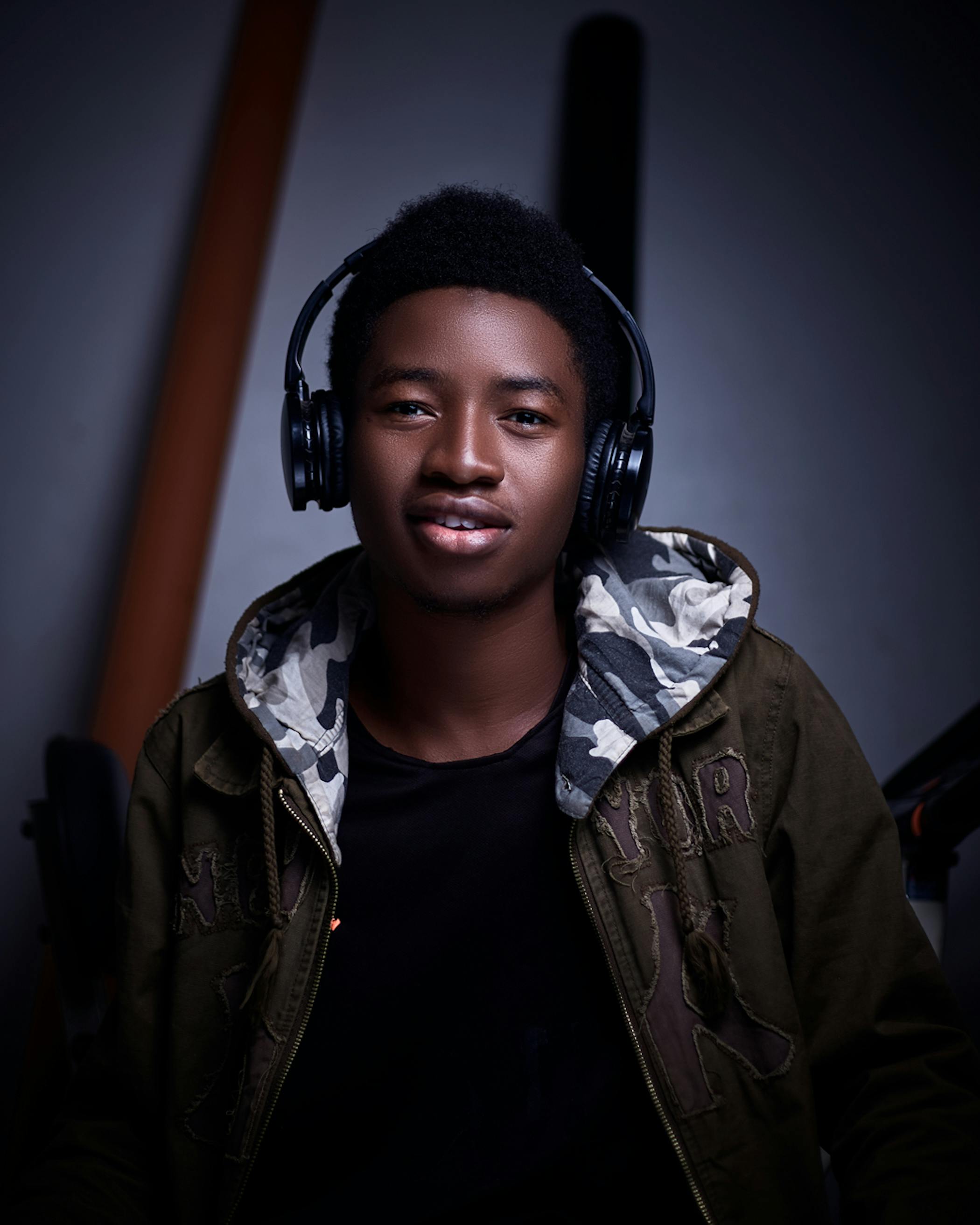 Free Captivating portrait of a young man with headphones, showcasing a confident expression in an indoor setting. Stock Photo