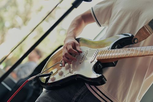 Free Musician playing electric guitar at outdoor performance, showcasing skill and passion. Stock Photo