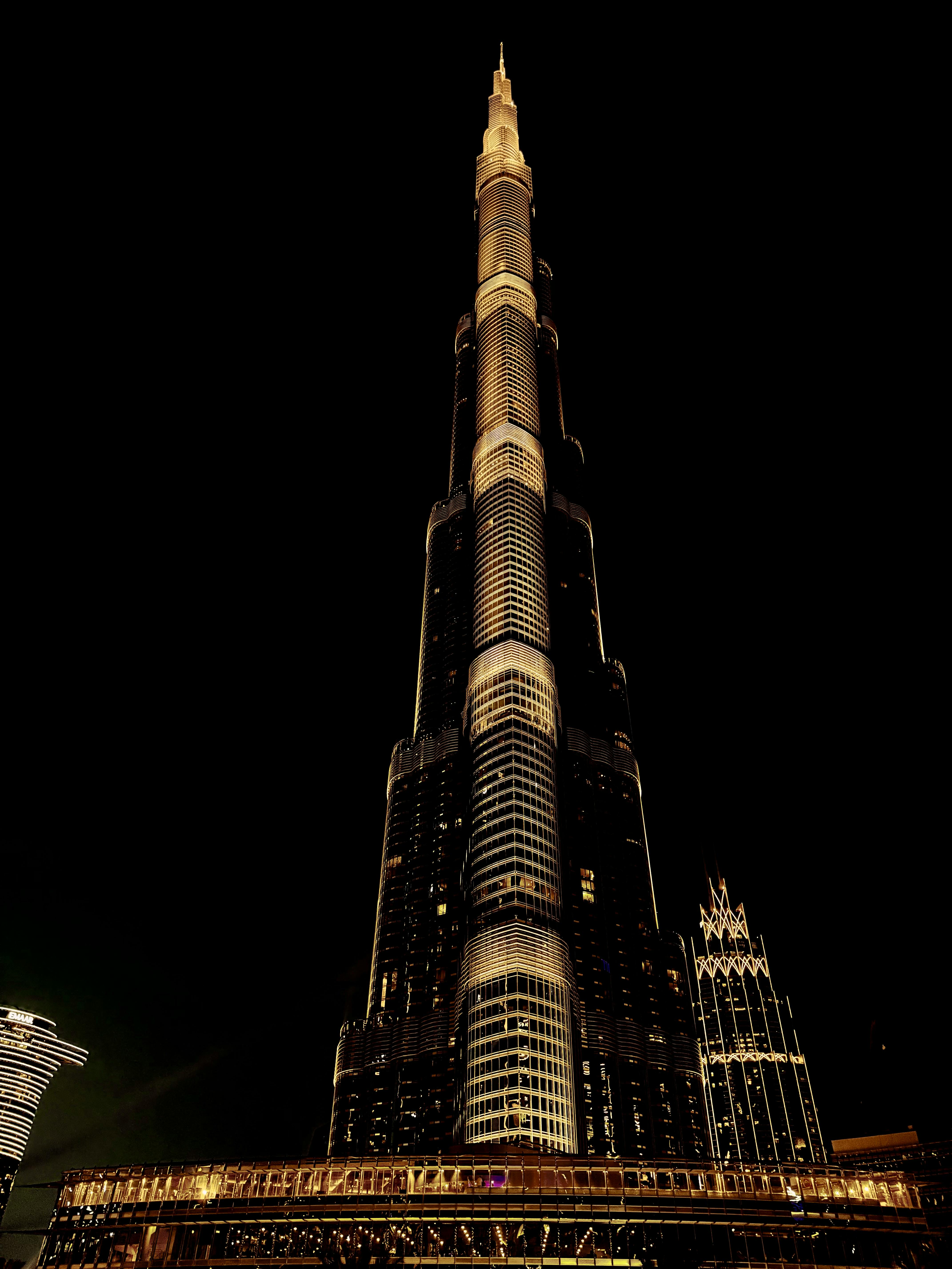 O Burj Khalifa em Dubai à noite, iluminado contra o céu escuro