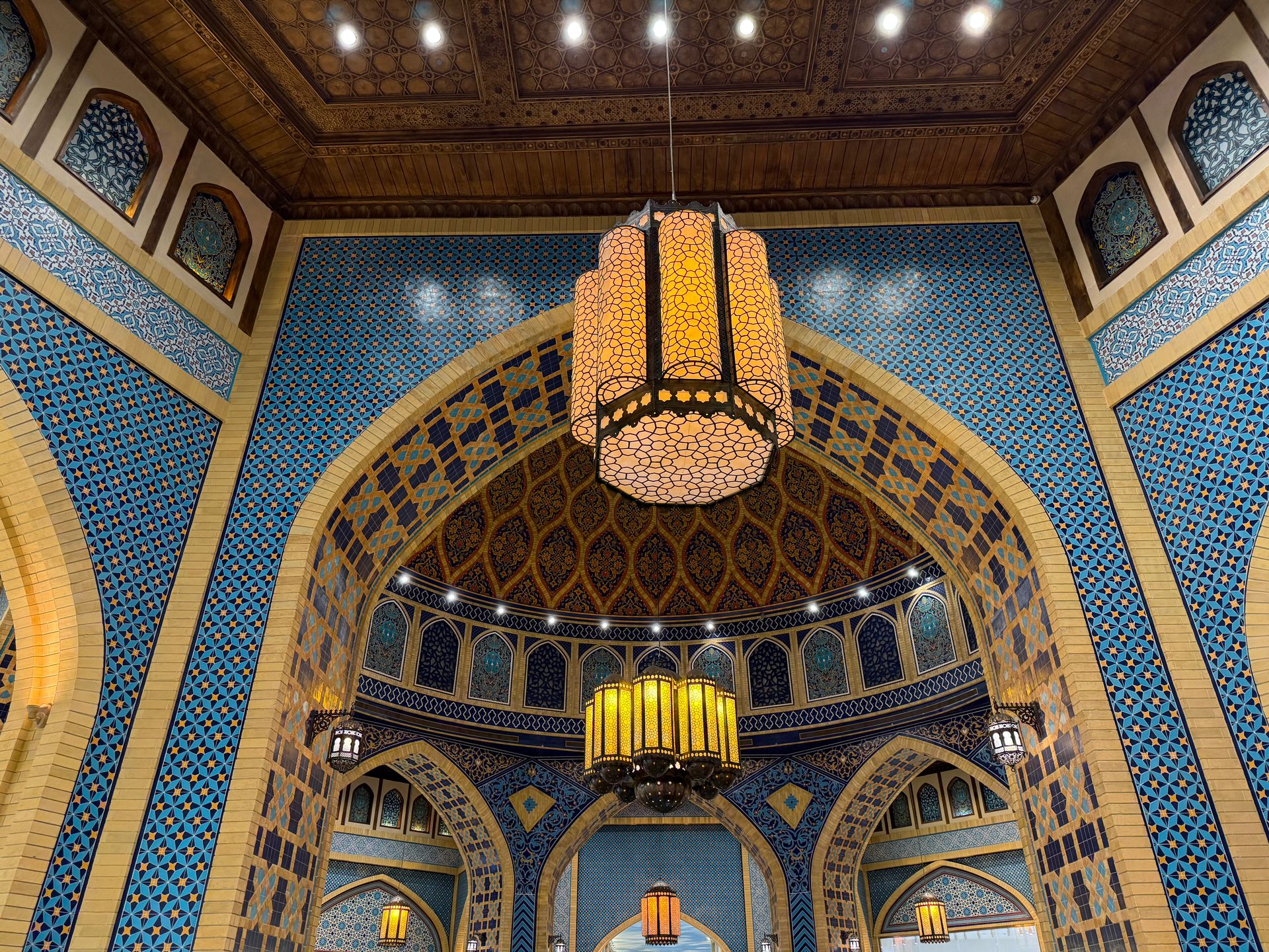 A stunning interior showcasing Islamic architecture with detailed tile work and traditional lanterns.