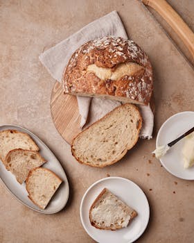 Delicious homemade sourdough bread with butter on a rustic table setting.