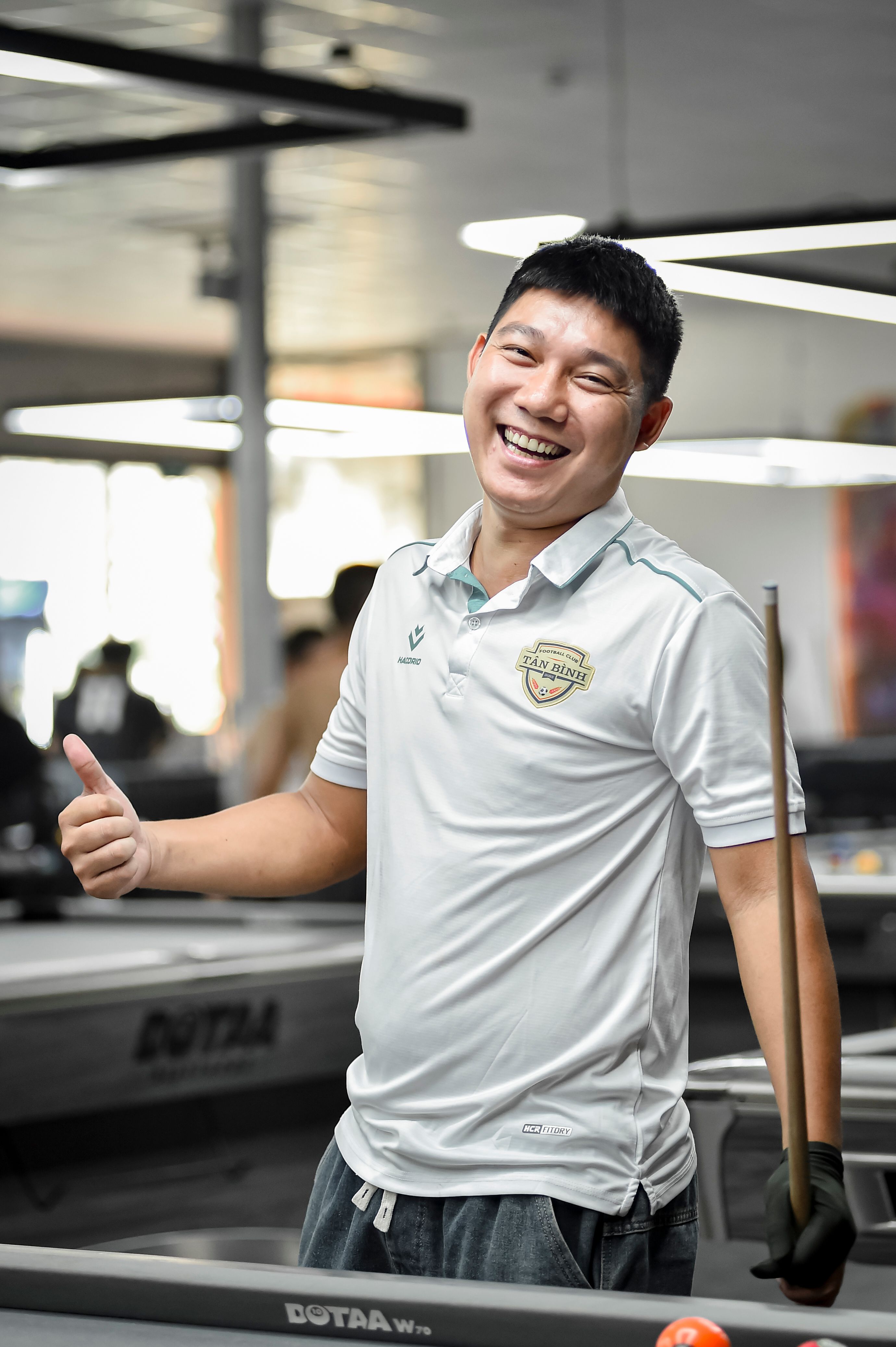 Smiling Man Playing Billiards in Indoor Venue