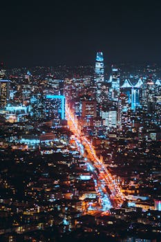 Aerial view of San Francisco's skyline with vibrant city lights and iconic architecture at night.