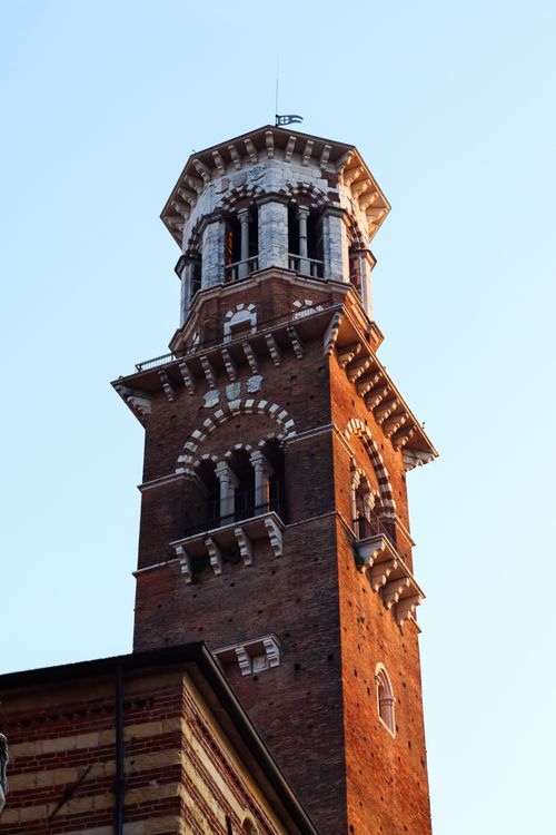 Free Close-up of a historic medieval brick tower against a clear blue sky. Stock Photo
