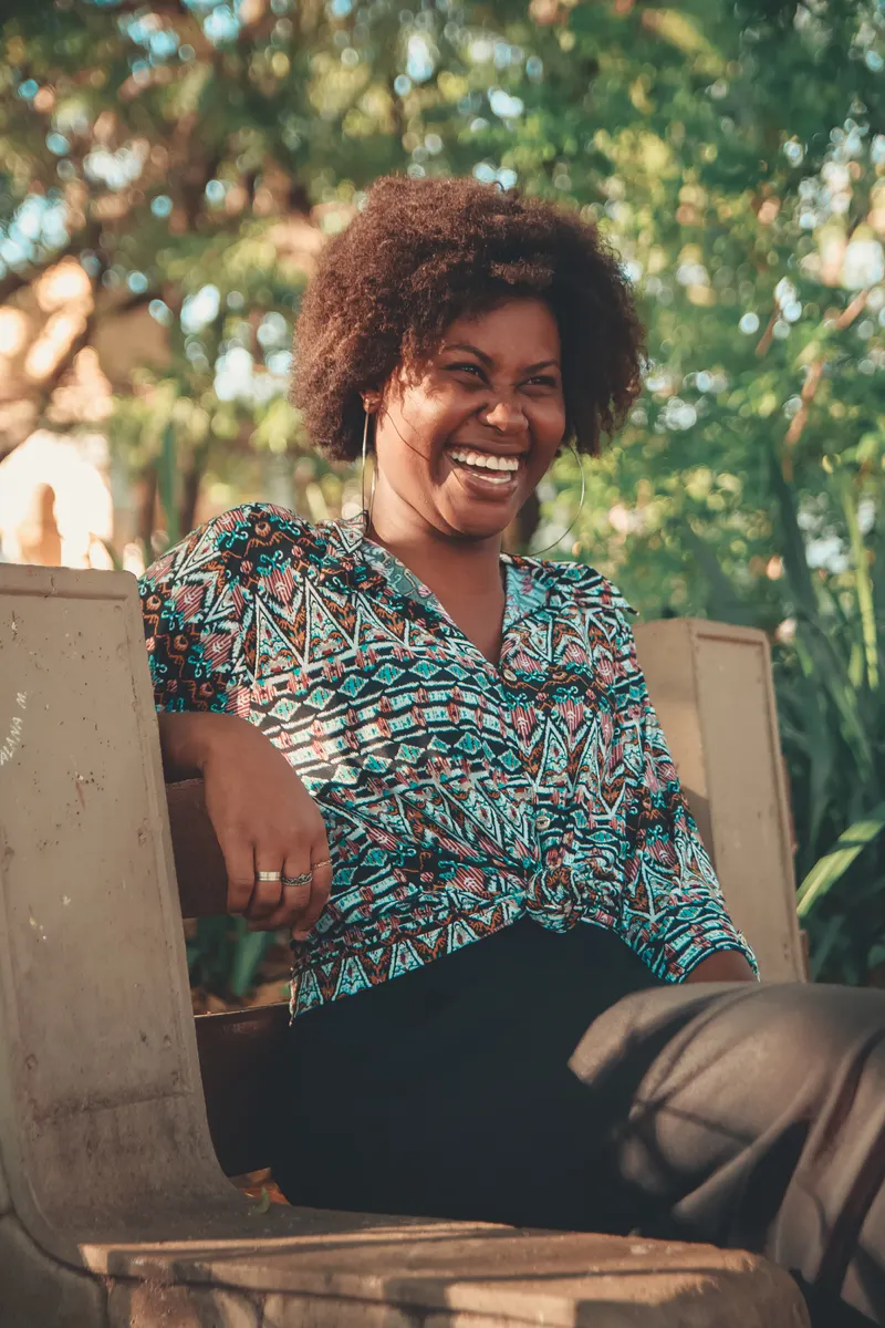 A woman laughing warmly in natural daylight