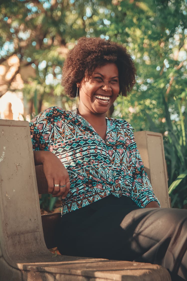 Woman Smiling And Sitting On Bench