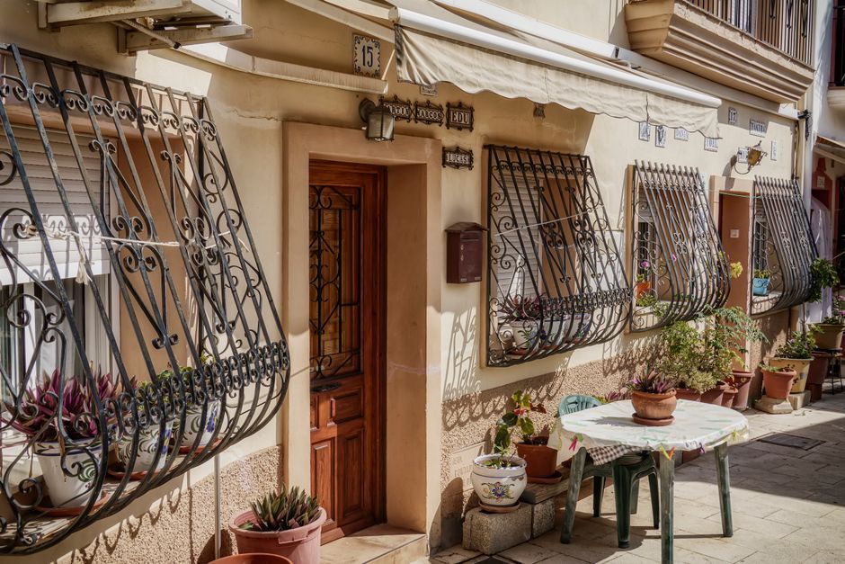Pintoresca escena de patio al aire libre con herrería decorativa en Alicante, España.