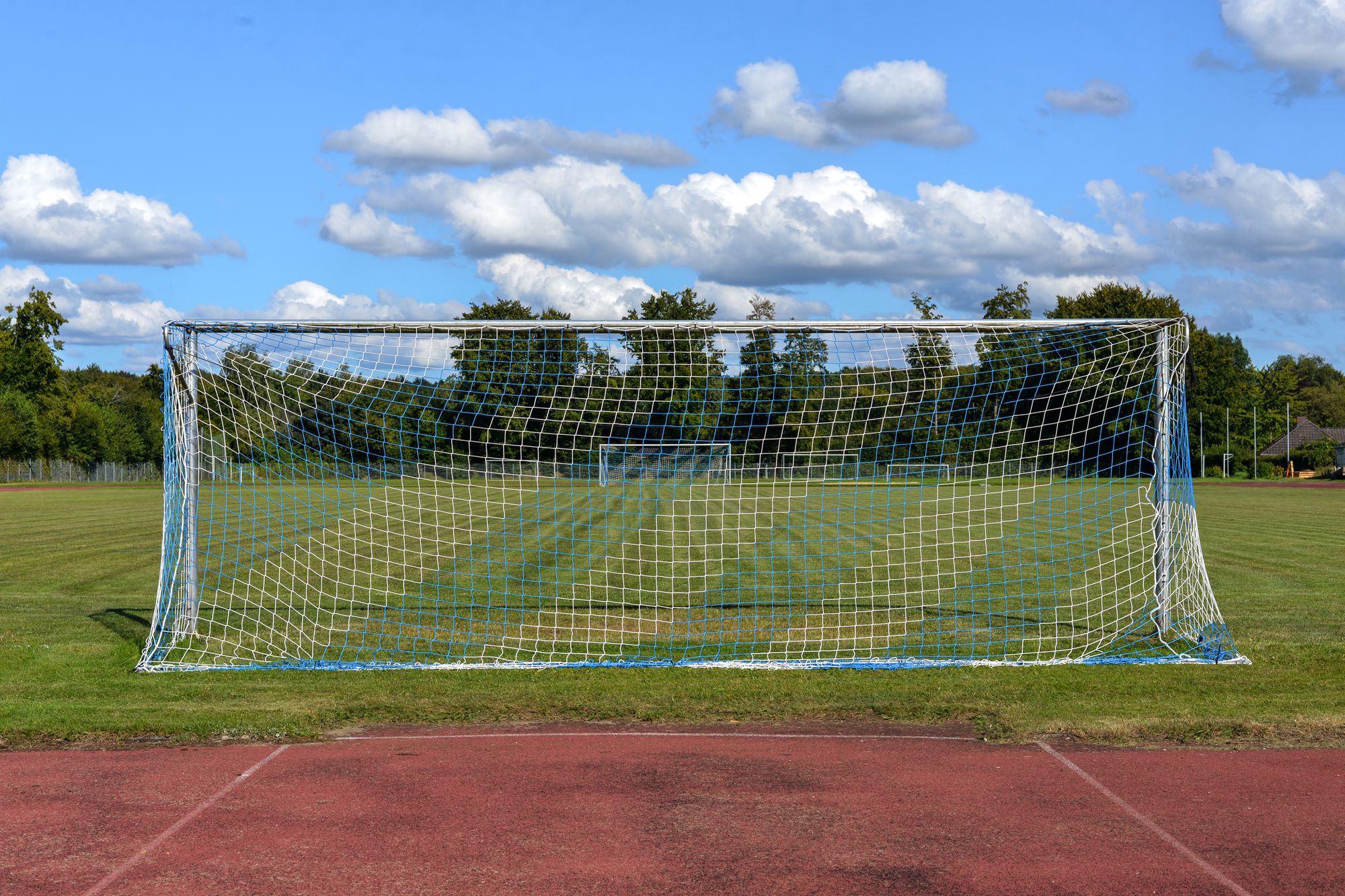 Portería vacía en una cancha de fútbol con césped natural