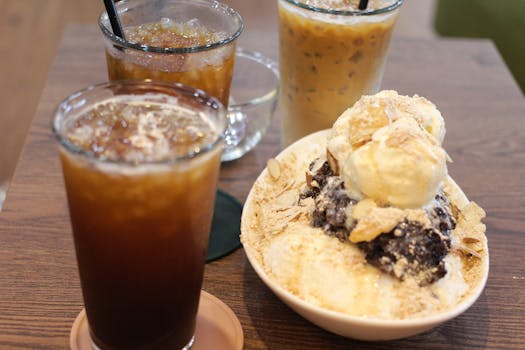 Enjoy iced coffee and Korean bingsu dessert with ice cream in a cozy cafe setting.
